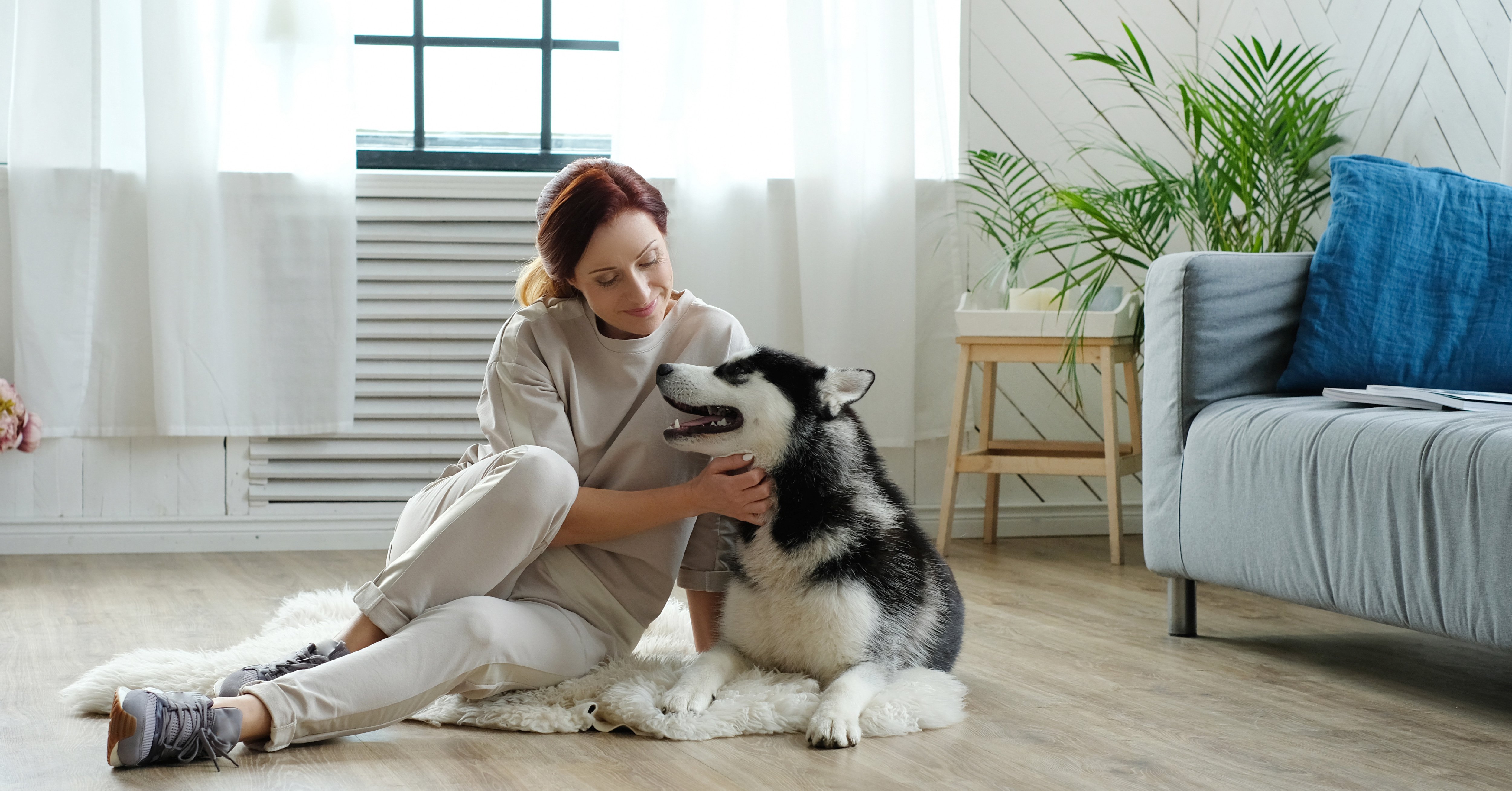 Woman with her dog sitting on the floor